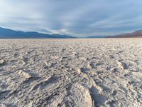 the dry out plain with no water on top of it is covered in sand, rocks and rocks