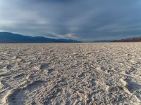 the dry out plain with no water on top of it is covered in sand, rocks and rocks