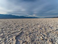 the dry out plain with no water on top of it is covered in sand, rocks and rocks