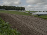 a dirt track is shown on a cloudy day with clouds overhead and a sign saying bsb