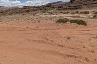 a desert scene with a man riding a motorcycle down it's side road in the desert