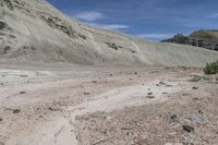 a person is riding a small motorcycle in the desert looking at a mountain pass with dirt and rocks