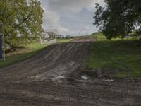 two men on dirt bikes are going through the course at an obstacle race on a cloudy day