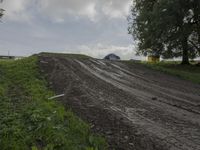 two men on dirt bikes are going through the course at an obstacle race on a cloudy day