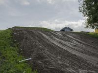 two men on dirt bikes are going through the course at an obstacle race on a cloudy day