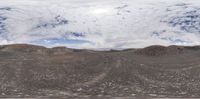 a man riding a snow board over top of a mountain of dirt and rocks below a blue sky