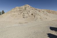 there is a bike rider on a paved dirt road through rocky area near a mountain