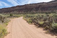 a dirt road winding in a valley with mountains in the background is an old style