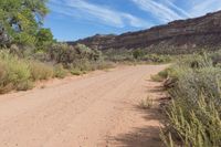 a dirt road winding in a valley with mountains in the background is an old style