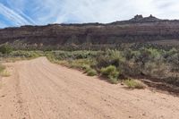 a dirt road winding in a valley with mountains in the background is an old style