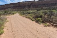 a dirt road winding in a valley with mountains in the background is an old style