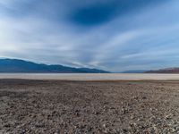 the dry, rocky lake bed on the side of a mountain range in the background