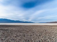 the dry, rocky lake bed on the side of a mountain range in the background