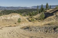 there is a bike rider on a paved dirt road through rocky area near a mountain