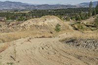 there is a bike rider on a paved dirt road through rocky area near a mountain