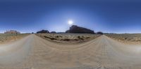 a fish eye view of desert and rocks and sky in a 360 - panoramic photo