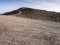 a truck on a dirt road in the desert with rocks and stones on the ground