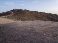 a truck on a dirt road in the desert with rocks and stones on the ground