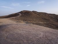 a truck on a dirt road in the desert with rocks and stones on the ground