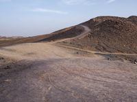 a truck on a dirt road in the desert with rocks and stones on the ground