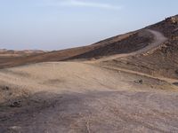 a truck on a dirt road in the desert with rocks and stones on the ground