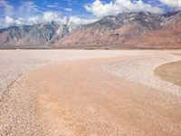 Off-Road Track in Mountain Range and Grass Plain