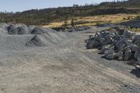 there is a bike rider on a paved dirt road through rocky area near a mountain