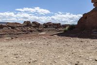 rocky ground with a dirt and rock slope in the distance, with a single motoble rider