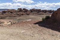 rocky ground with a dirt and rock slope in the distance, with a single motoble rider