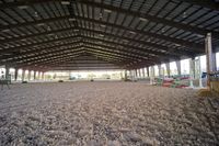 an indoor arena for horses, with horse stalls and equipment for a horse show or horseback riding
