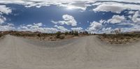 360 - angle view of a dirt road in the middle of nowhere with clouds above