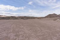 a dirt field in the middle of nowhere with rocks and dirt around it and a lone horse