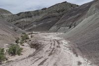 dirt is coming down the steep mountainside in the desert on a sunny day with sparse vegetation