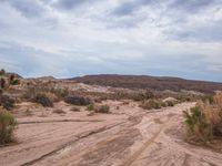 an atv parked in the desert with rocks and bushes to its side near the top