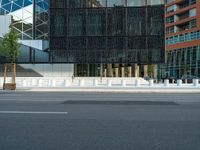 motion blurers as a car passes by a modern building in a city with a large metal screen behind