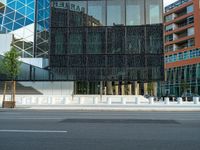 motion blurers as a car passes by a modern building in a city with a large metal screen behind