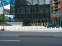 motion blurers as a car passes by a modern building in a city with a large metal screen behind