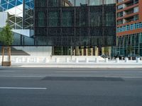 motion blurers as a car passes by a modern building in a city with a large metal screen behind