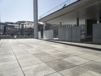 a concrete floor with a small fence on top of it outside a building that is next to the stairs