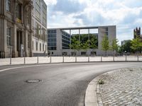 street sign sitting on side of road in front of some large buildings that have windows