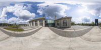 a very wide view of an office building with no one on it and a bench