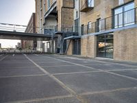 an outdoor walkway leading to an industrial structure with balconies on it and a metal stair case