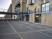 an outdoor walkway leading to an industrial structure with balconies on it and a metal stair case