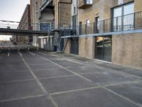 an outdoor walkway leading to an industrial structure with balconies on it and a metal stair case