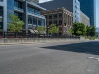 an empty street with buildings and parked cars on the sidewalks and green lanes on the sidewalk