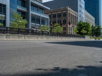 an empty street with buildings and parked cars on the sidewalks and green lanes on the sidewalk