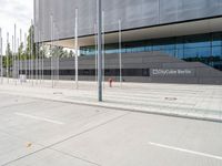 a large building with several metal poles and poles near it are two red fire hydrants and there's an empty parking space