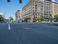 an empty street with buildings and parked cars on the sidewalks and green lanes on the sidewalk