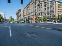 an empty street with buildings and parked cars on the sidewalks and green lanes on the sidewalk