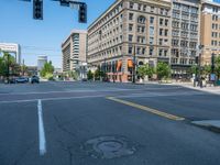 an empty street with buildings and parked cars on the sidewalks and green lanes on the sidewalk